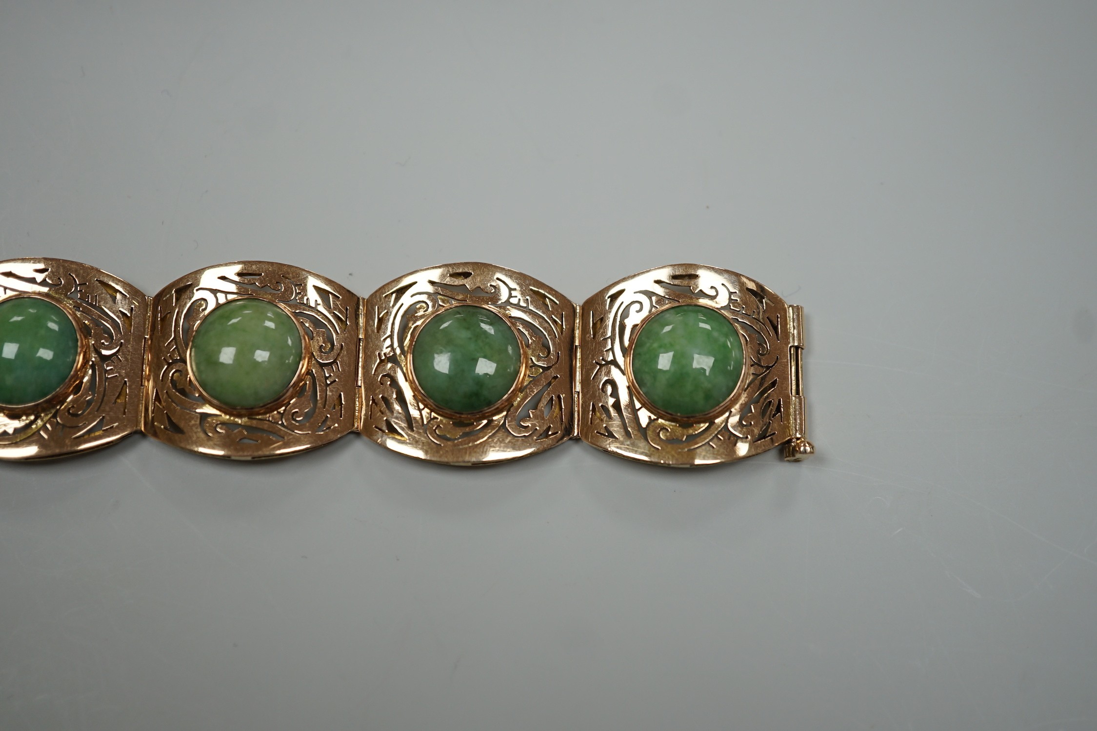 A continental 18k yellow metal and seven stone cabochon jade set bracelet, with pierced links, 18.5cm, gross weight 39.3 grams.